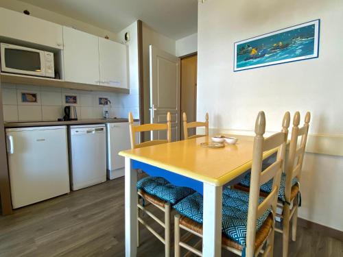 une cuisine et une salle à manger avec une table et des chaises dans l'établissement REF 060 Appartement pour quatre personnes résidence avec piscine vue Port Crouesty ARZON, à Arzon