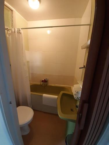 a bathroom with a toilet and a tub and a sink at hotel Melissa in Péruwelz