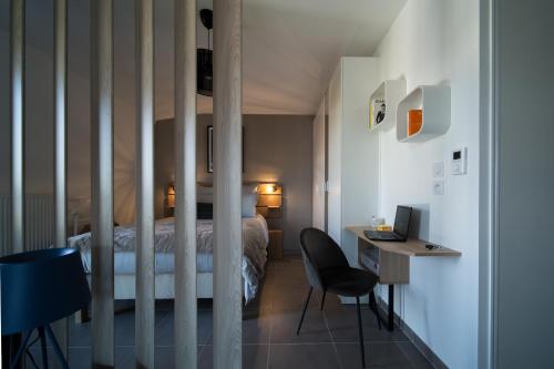 a bedroom with a bed and a desk with a computer at LES MYRTILLES Aix les Bains in Aix-les-Bains