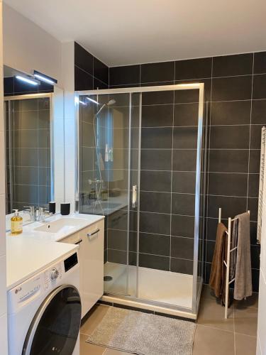 a bathroom with a shower and a washing machine at LES MYRTILLES Aix les Bains in Aix-les-Bains