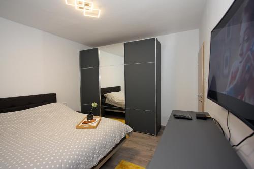 a bedroom with a bed and a flat screen tv at Apartment Petra in Supetar