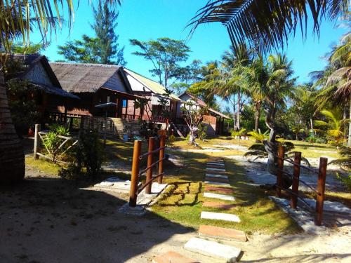 a path leading to a house with a fence at Asari Timo Cottage in Karimunjawa