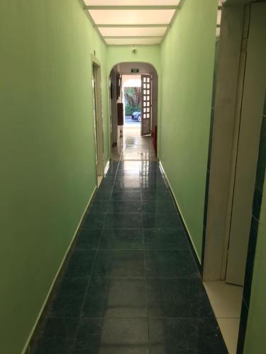an empty hallway with green walls and a tile floor at Tita’s Airport Hotel in Cartagena de Indias