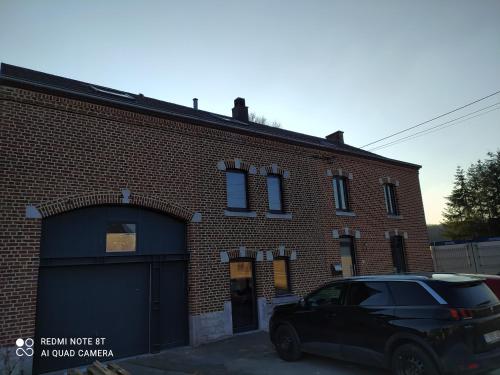 a black car parked in front of a brick building at Balade en amoureux au calme in Rochefort