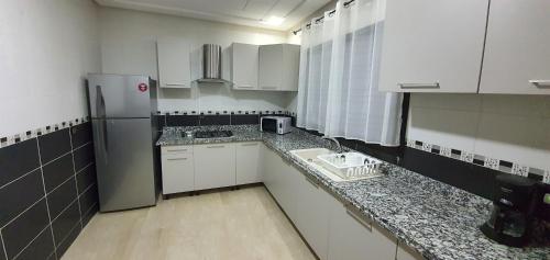 mała kuchnia z białymi szafkami i lodówką w obiekcie Villa Nour w Fezie