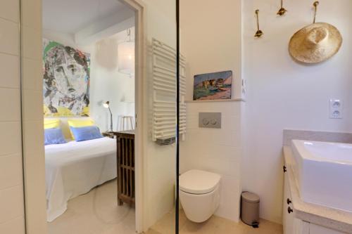 uma casa de banho com uma cama, um WC e um lavatório. em Le Bastidon de PAMPELONNE em Saint-Tropez