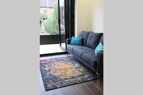 a living room with a couch and a rug at Boutique Stylish Self Contained Studio Shropshire in Pattingham