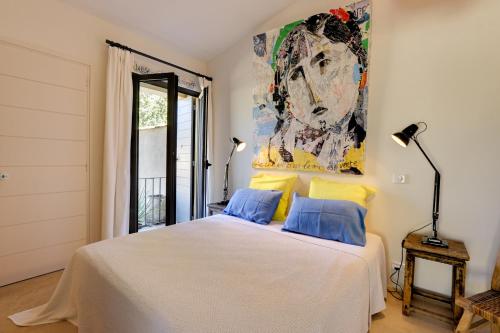 Schlafzimmer mit einem Bett mit Wandgemälde in der Unterkunft Le Bastidon de PAMPELONNE in Saint-Tropez