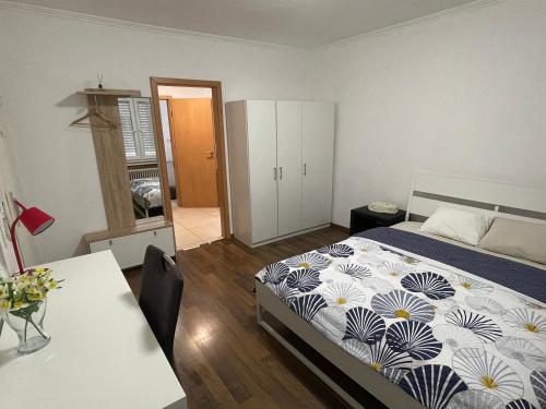 a bedroom with a bed and a desk and a table at Apartment CHEZ TONY in Strassen