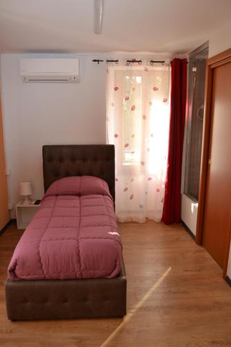 Bett in einem Zimmer mit Fenster in der Unterkunft Casa Yoghi in Cadenazzo