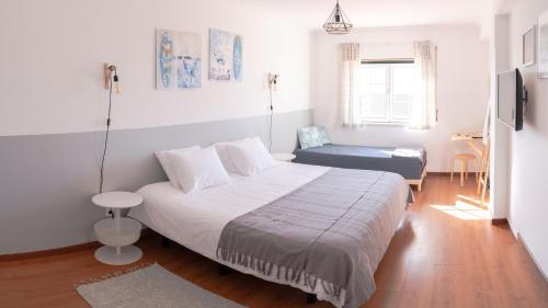 1 dormitorio con 1 cama y 1 silla en Perfect Shore Guest House, en Baleal