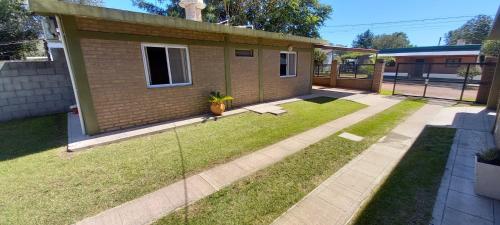 a backyard with a house with a grass yard at Santa isabel in Embalse