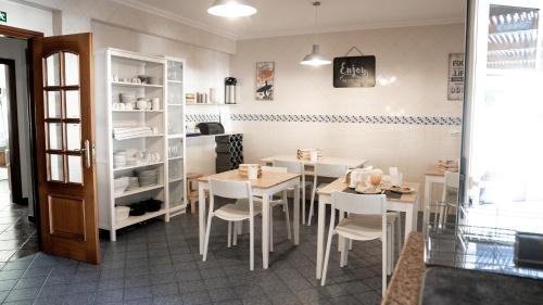 a restaurant with white tables and chairs in a room at Perfect Shore Guest House in Baleal