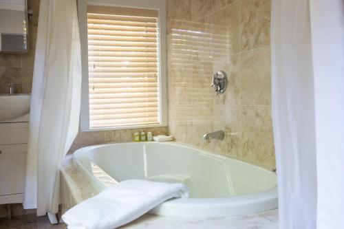 uma banheira branca na casa de banho com uma janela em Hotel Pippa em Nantucket