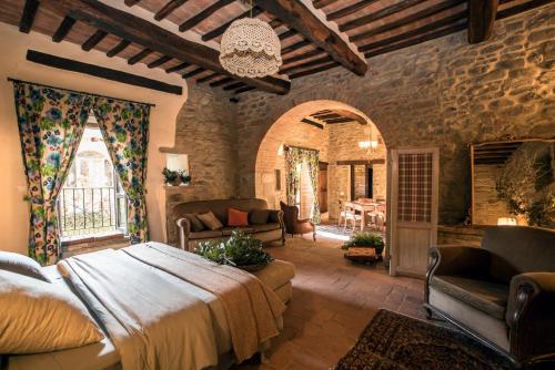 Agriturismo Frantoio Valiani في كورتونا: غرفة نوم بسرير كبير وغرفة معيشة