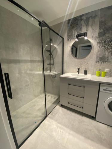 a bathroom with a shower and a sink and a mirror at Apartament Wiczlino in Gdynia