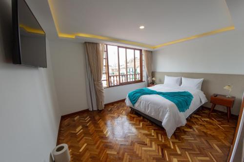 um quarto com uma cama e uma grande janela em Hotel Boutique San Marcos Chiquinquirá em Chiquinquirá