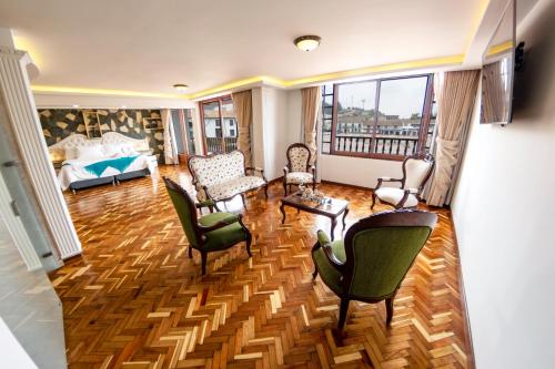 a living room with chairs and a bed and a couch at Hotel Boutique San Marcos Chiquinquirá in Chiquinquirá