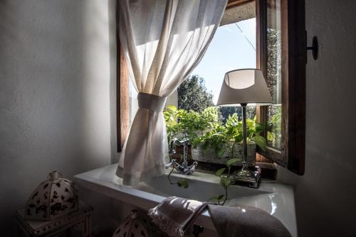 a window with a curtain and a lamp on a sink at Agriturismo Frantoio Valiani in Cortona