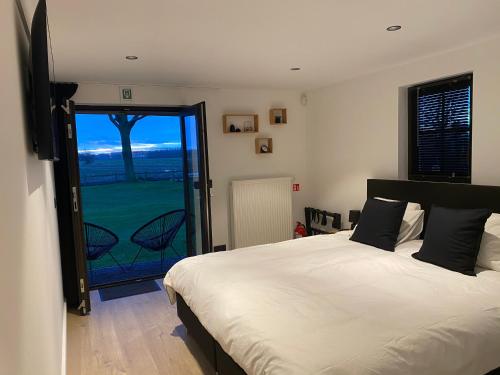a bedroom with a bed and a sliding glass door at Damse Paveljoentje comfort en uitzicht in Damme in Damme