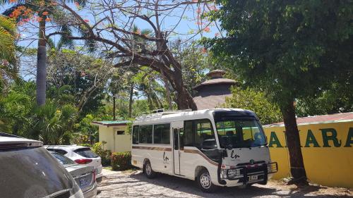 a small white bus parked in a parking lot at Samara Beach Hotel in Sámara