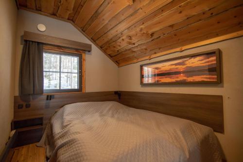 a bedroom with a bed in a room with a window at Villa Ankkuri in Savonranta