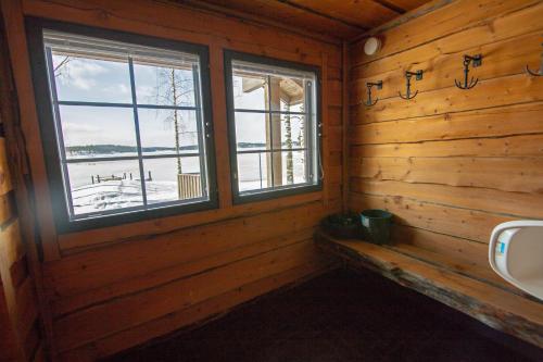 a bathroom with two windows in a log cabin at Villa Ankkuri in Savonranta