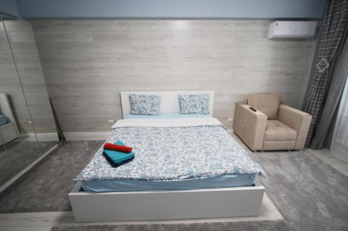 a small bedroom with a bed and a chair at Нурсая#2 in Atyraū