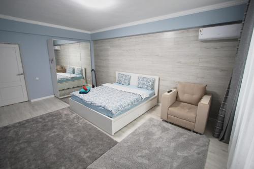 a small bedroom with a bed and a chair at Нурсая#2 in Atyraū