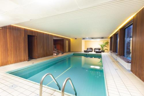 a large swimming pool in a building with a pool at Montana Landhotel Gummersbach-Nord in Marienheide