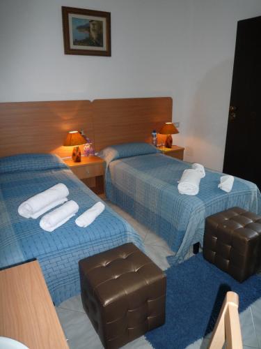 a hotel room with two beds and a chair at La Valle Verde hotel ristorante pizzeria in Zambrone