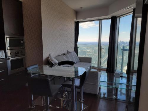 a living room with a couch and a glass table at Two BD CN Tower and Lake Ontario View in Toronto