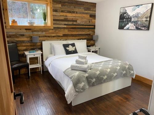 a bedroom with a bed and a wooden wall at Journey's End - 2 bed 1 bath Suite in Golden