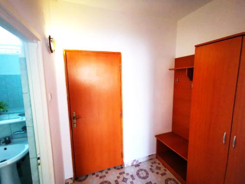 La salle de bains est pourvue d'une porte en bois et d'un lavabo. dans l'établissement Hotel Berlin, à Eforie Nord