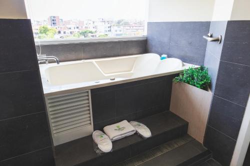 a bathroom with a tub and a sink and a window at Palmetto Hotel Business San Miguel in Lima