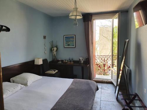 a bedroom with a bed and a window and a desk at Le Bistrot Vinaigrette in Prades-le-Lez