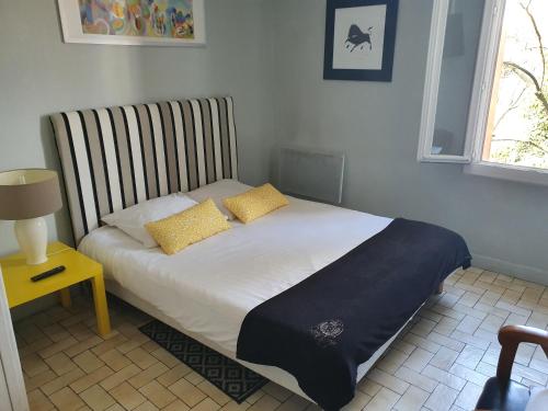a bed with two pillows on it in a bedroom at Le Bistrot Vinaigrette in Prades-le-Lez