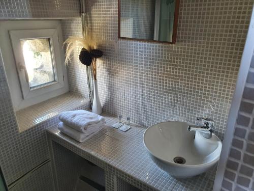 a bathroom with a sink and a mirror and a window at Le Bistrot Vinaigrette in Prades-le-Lez
