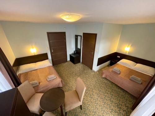 a hotel room with two beds and a table and chairs at Baltic Sun SPA in Rewal