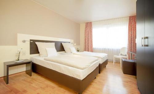 a hotel room with two beds and a window at Hotel Europa in Bonn