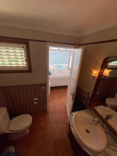 łazienka z toaletą, umywalką i lustrem w obiekcie Villa Caleton w Puerto del Carmen