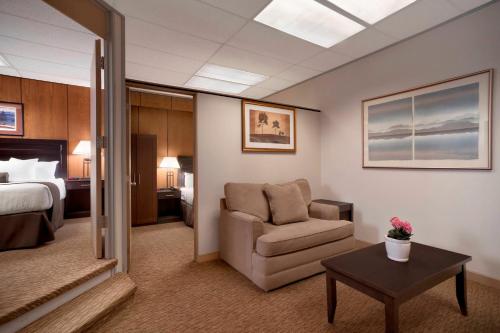 a hotel room with a chair and a bed at Days Inn & Suites by Wyndham Sault Ste. Marie ON in Sault Ste. Marie