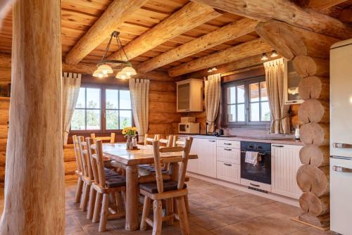 a kitchen with a wooden table and chairs at Apartmány Srub Výtoňka Lipno in Přední Výtoň