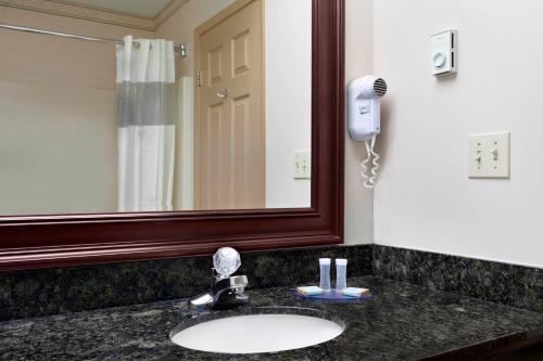 a bathroom with a sink and a mirror at Days Inn & Suites by Wyndham Sault Ste. Marie ON in Sault Ste. Marie