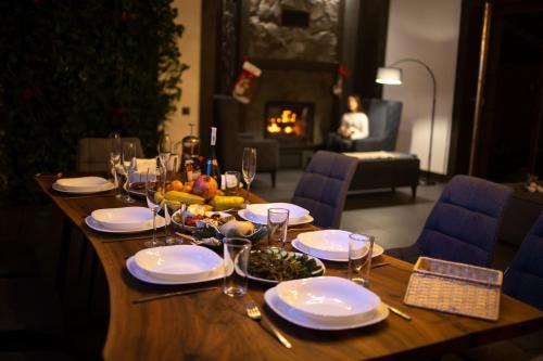 a wooden table with plates and wine glasses on it at Apart-hotel Vershina in Yaremche