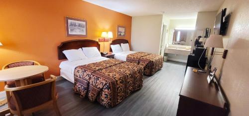 Habitación de hotel con 2 camas y mesa en Regency Travel Inn, en Hayti