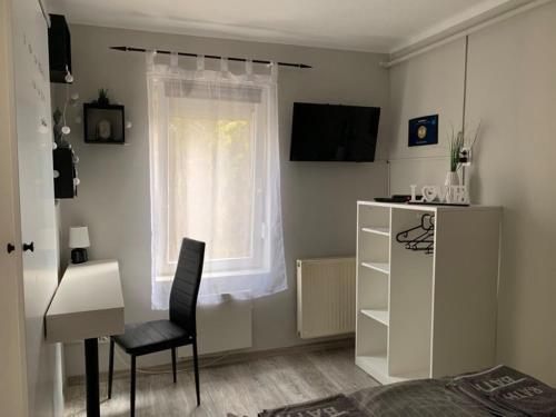 ヴェレシェクハーズにあるMandi apartmanのベッドルーム(デスク、椅子、窓付)