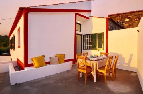 comedor con mesa y sillas en el patio en FISH HOUSE 1, en Prainha de Cima