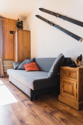 a blue couch in a room with a wooden table at L'écrin du Vernon in Chamrousse