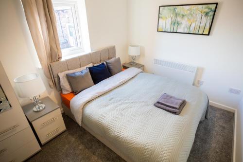 a bedroom with a large bed with pillows and a window at Sigma Executive Apartment 6 in North Shields